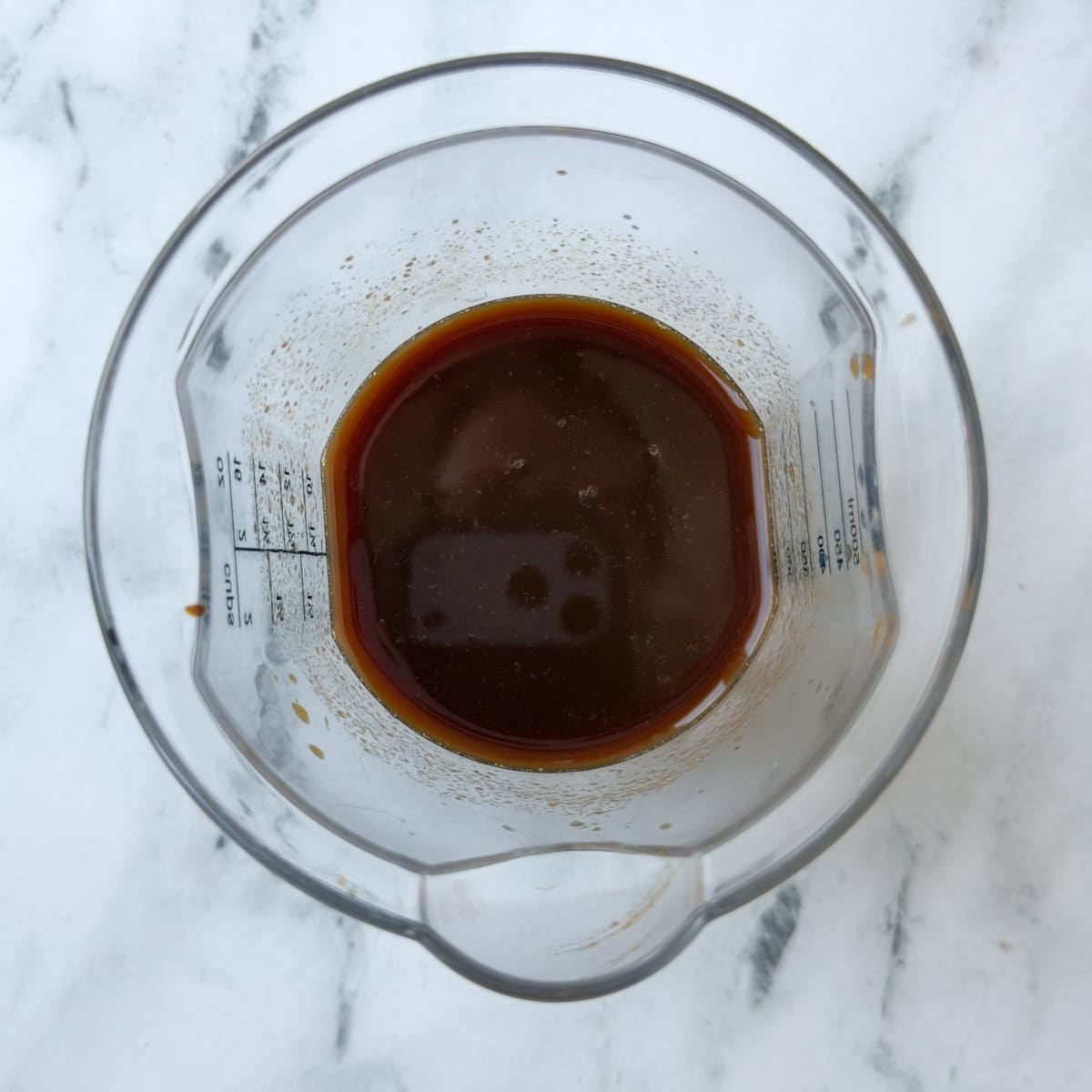 Broth, vinegar, Worcestershire, tomato paste, and more mixed for a slow cooking broth for pulled pork.