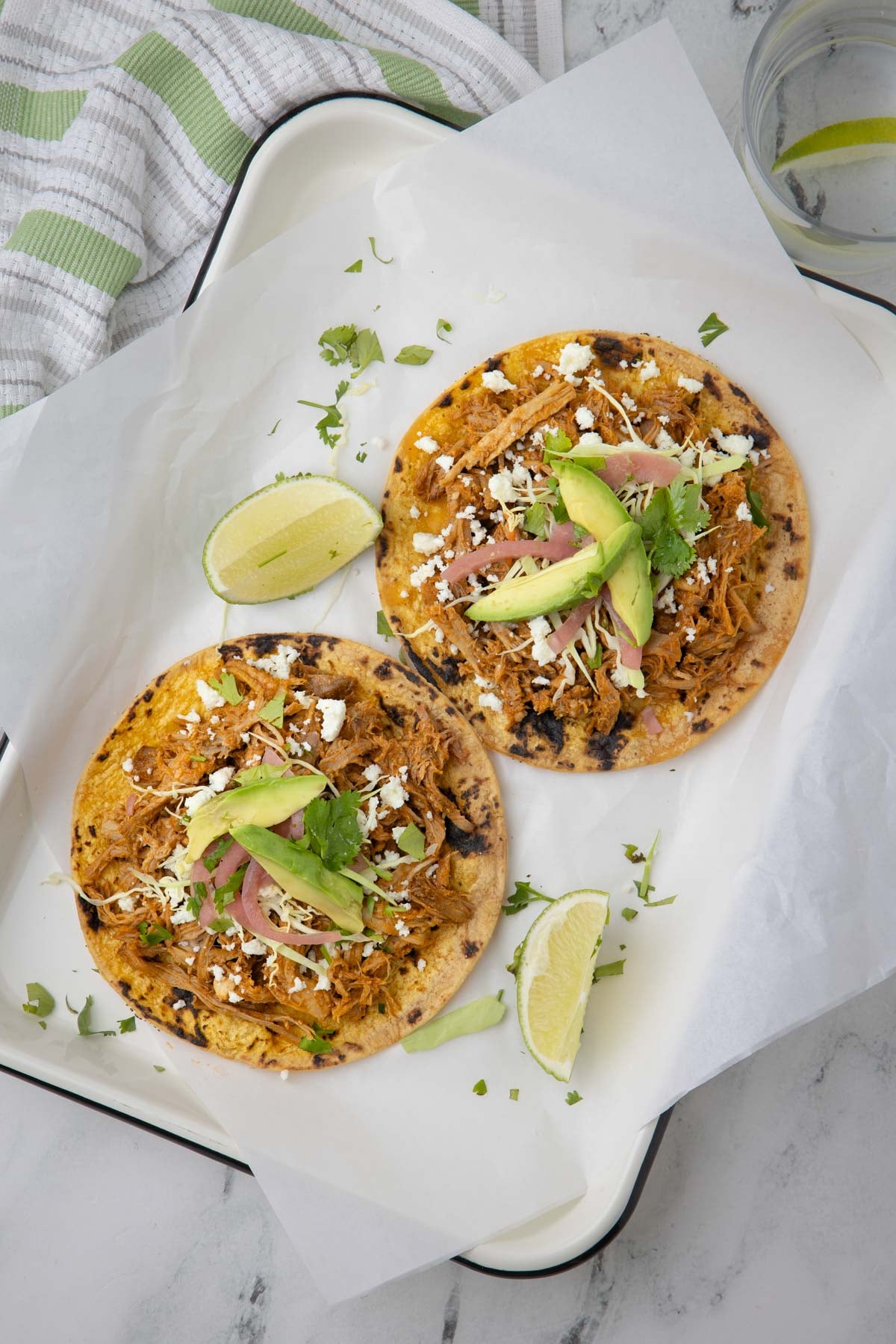 Pulled pork tacos o corn tortillas with cabbage, pickled onions, and avocado.