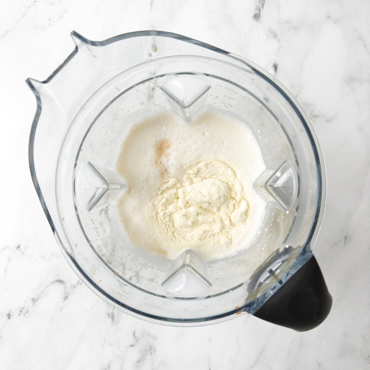 Cream, milk, vanilla, milk powder in a blender container to be blended.
