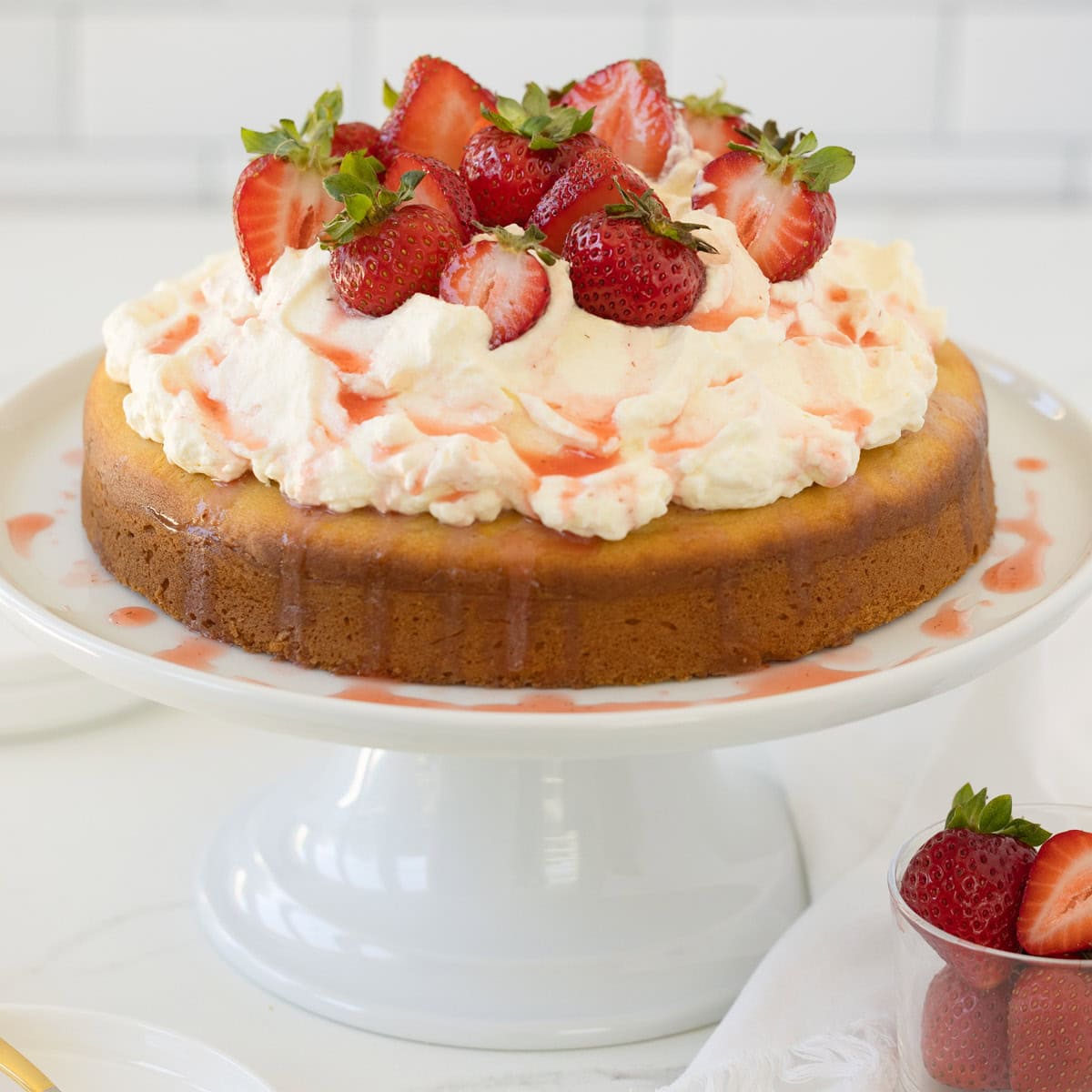 Strawberry shortcake cake with fresh strawberries and whipped cream on a golden single layer cake.