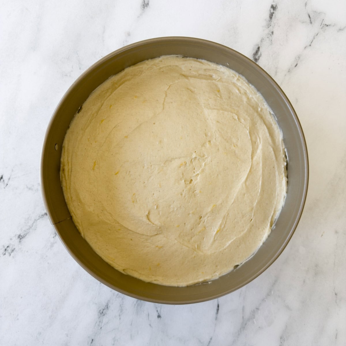 Batter smoothed into a cake pan ready for baking.