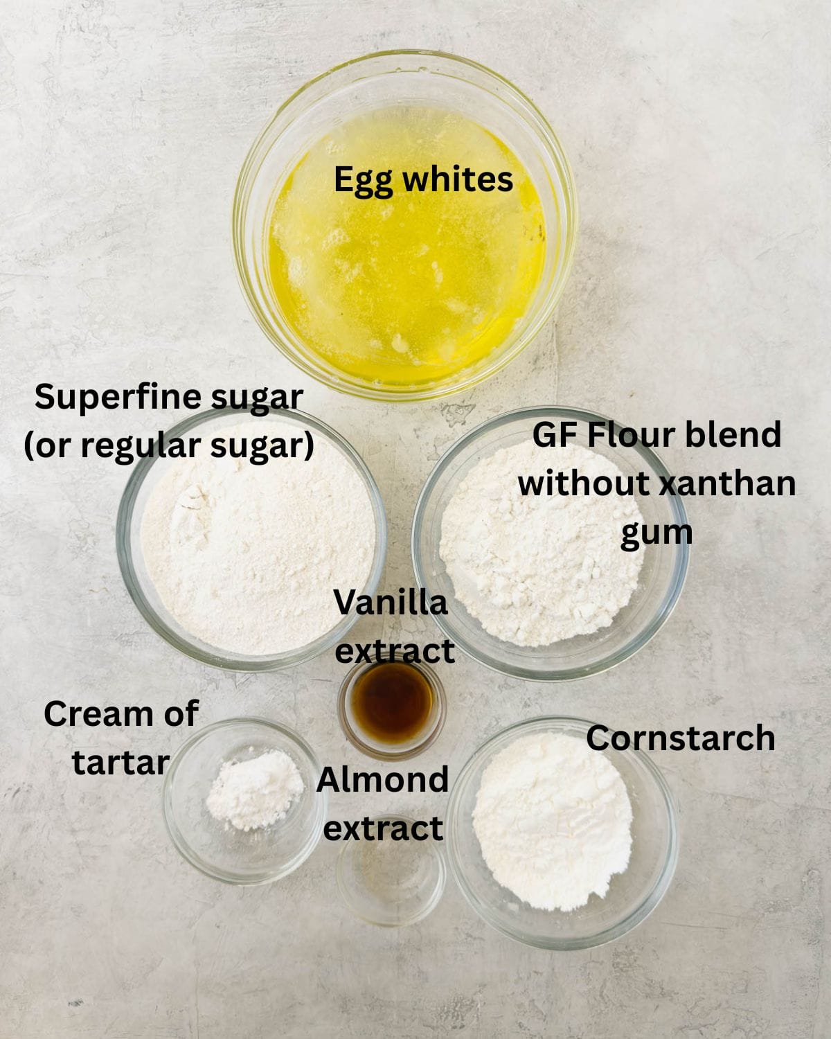 Gluten-free angel food cake ingredients in prep bowls on a kitchen counter.