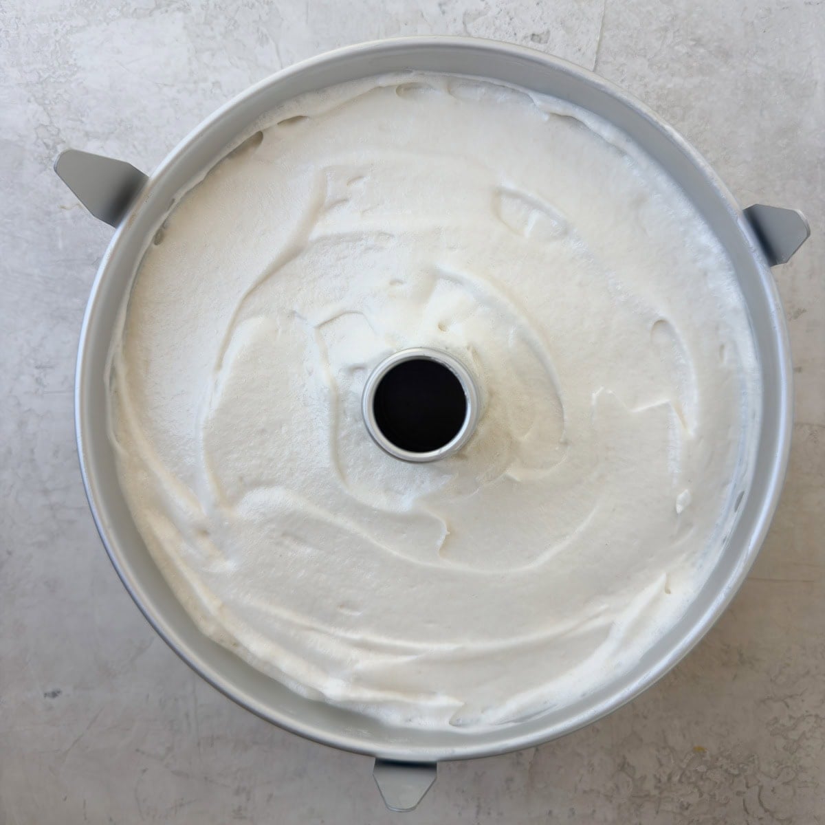 Finished angel food cake batter smoothed into the tube cake pan ready to bake.