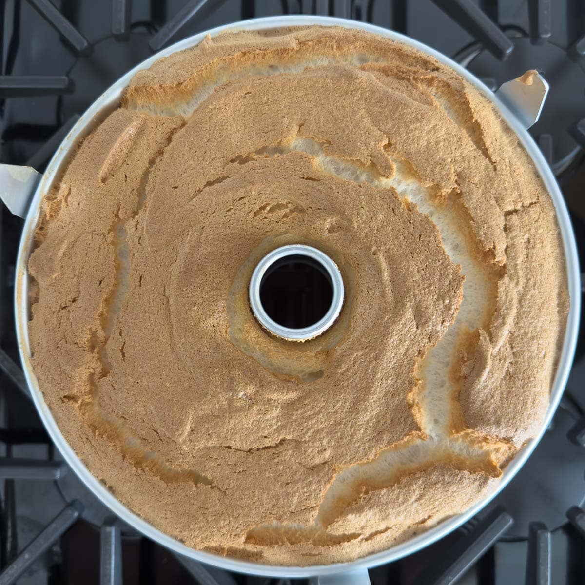A golden baked angel food cake still in the pan.