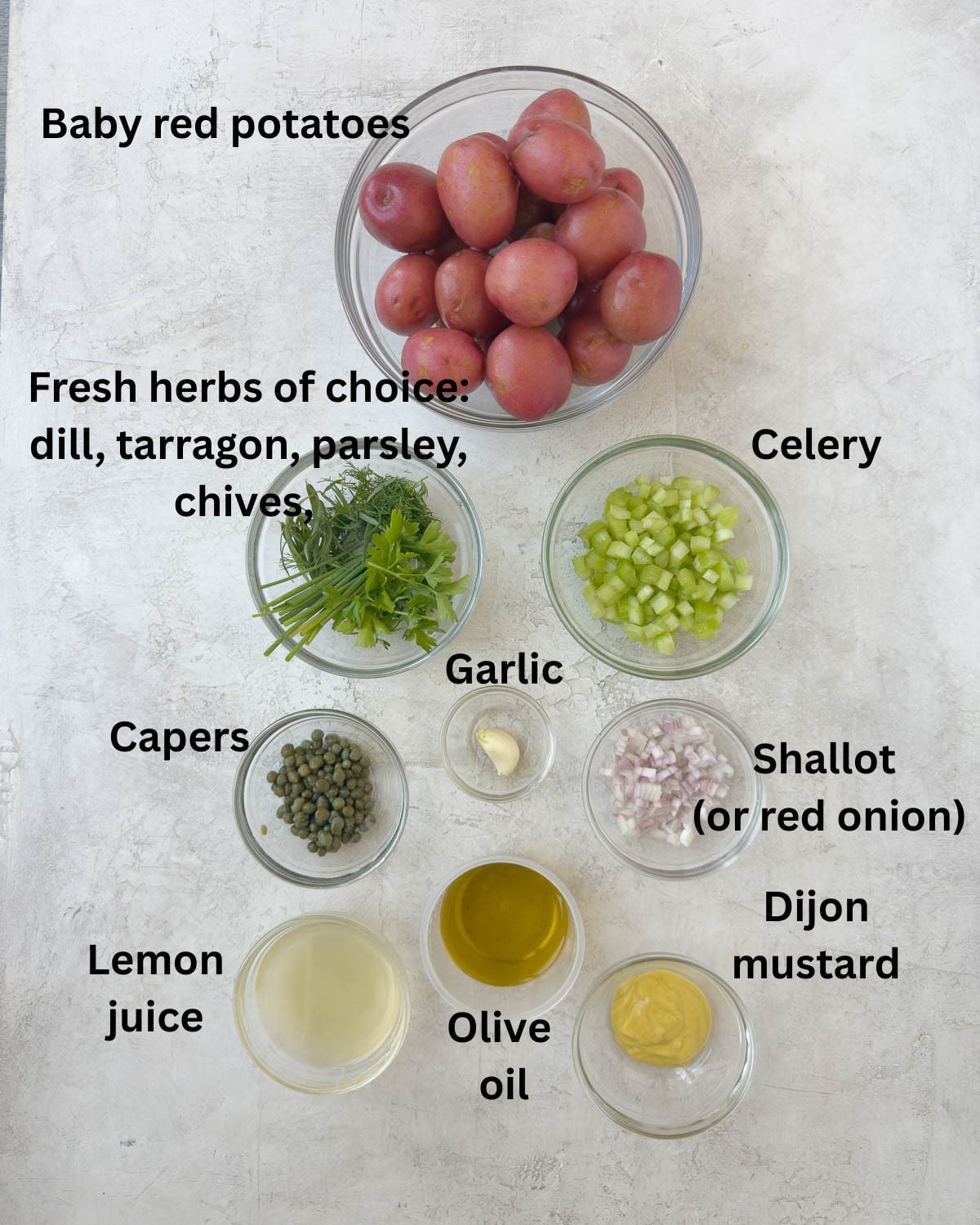 Ingredients for red potato salad in prep bowls on a counter.
