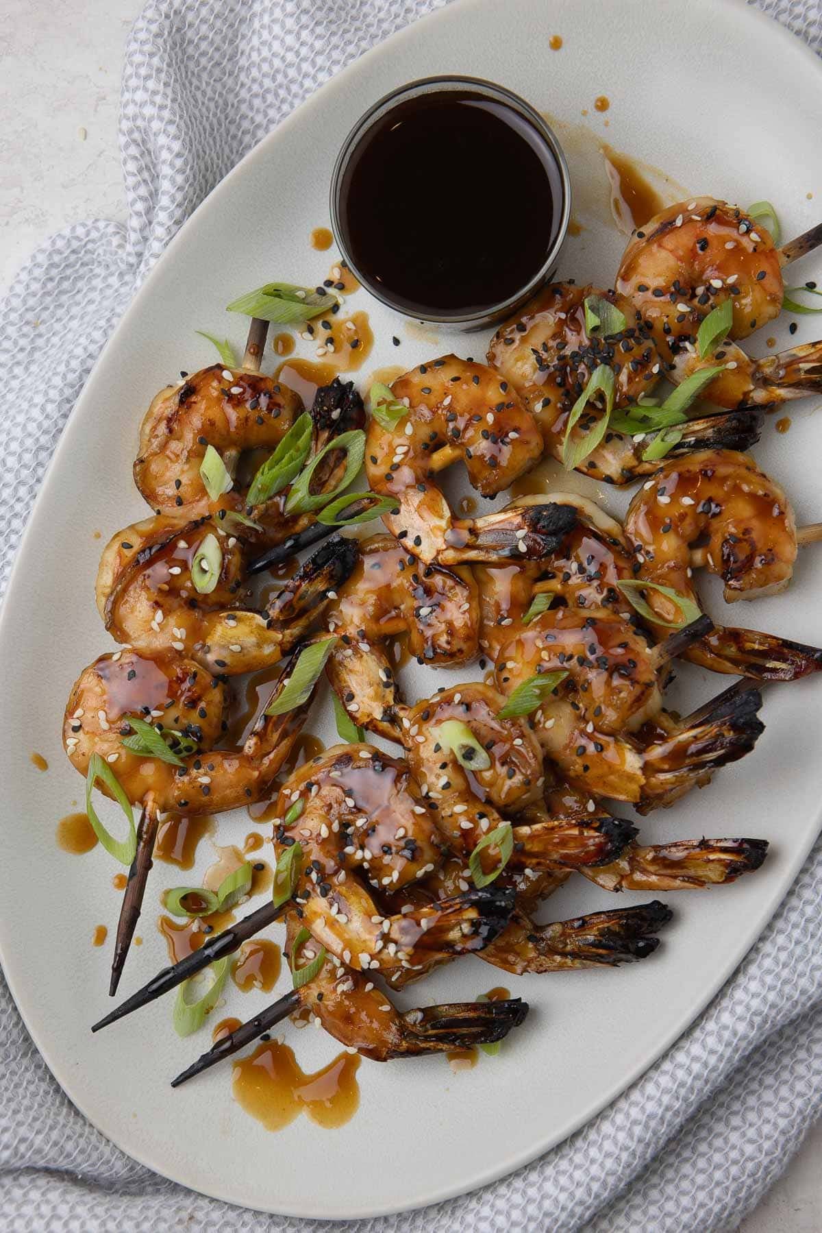 Glazed teriyaki shrimp, grilled on bamboo skewers with black and white sesame seeds and green onions.