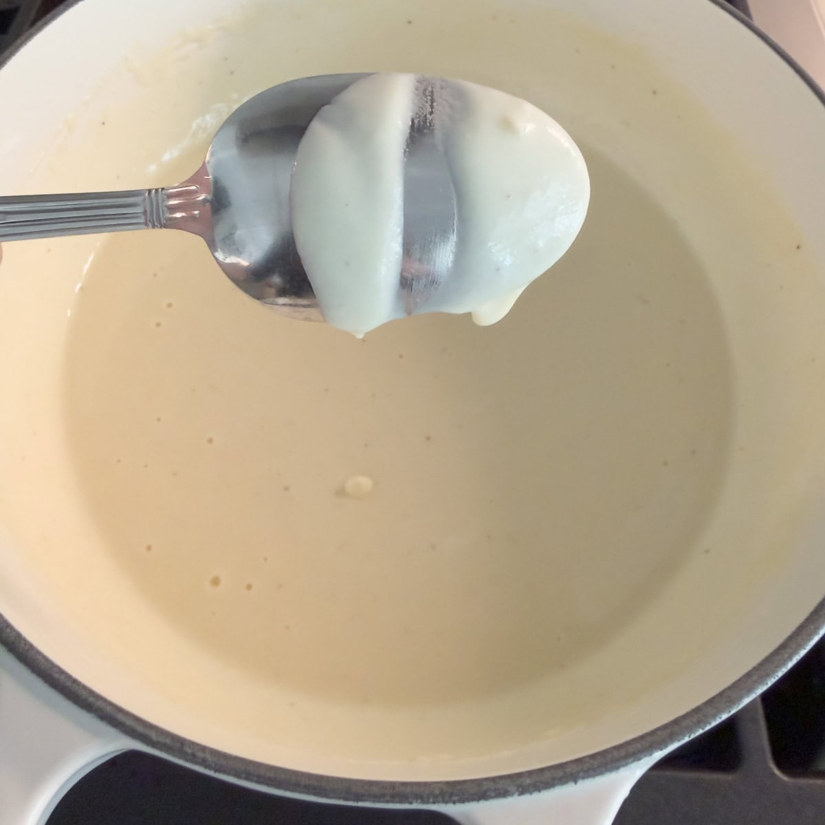 Thickened cottage cheese alfredo sauce coating the back of a spoon.