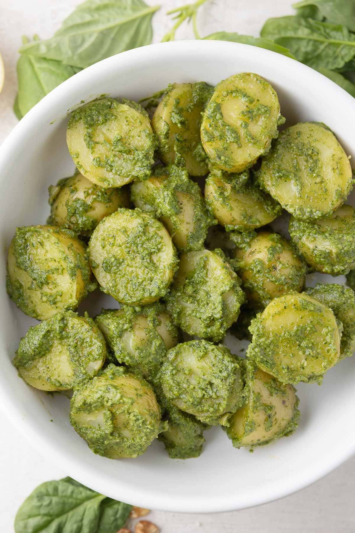 A bowl of baby gold potatoes tossed with spinach pesto ready to serve.