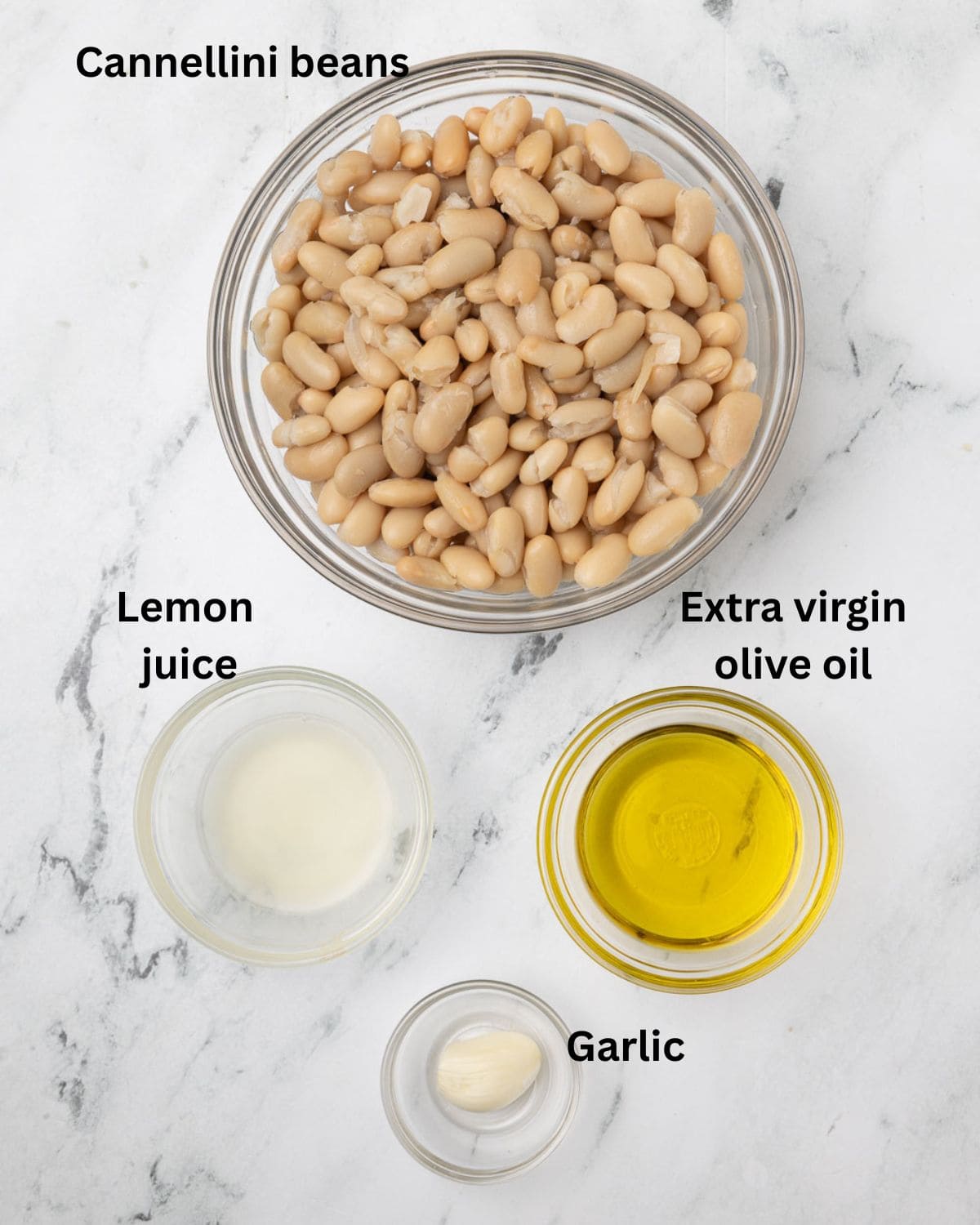 Cannellini beans, olive oil, lemon juice, and garlic in prep bowls foe white bean dip.