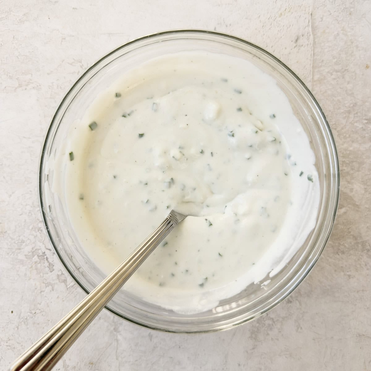 Finished yogurt blue cheese dressing, mixed by hand in a bowl.