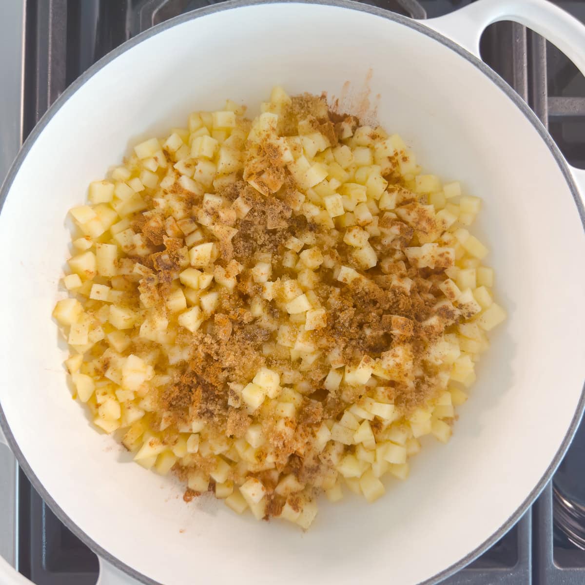 Cooking diced apples for turnover filling with cinnamon.