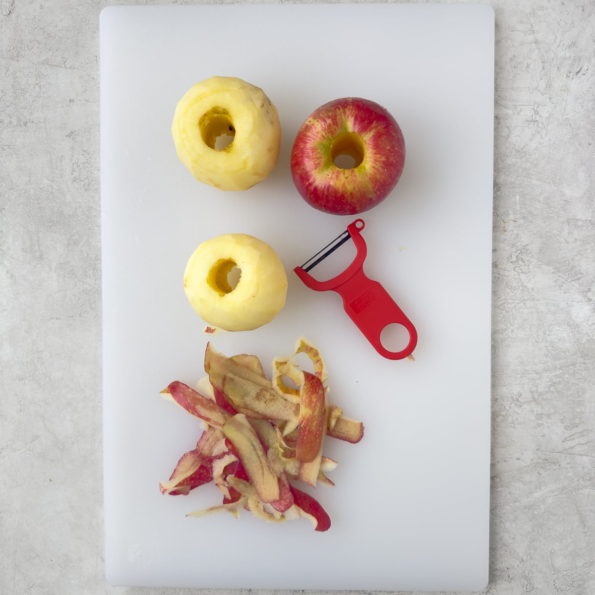 Peeling and coring honeycrisp apples with a peeler.