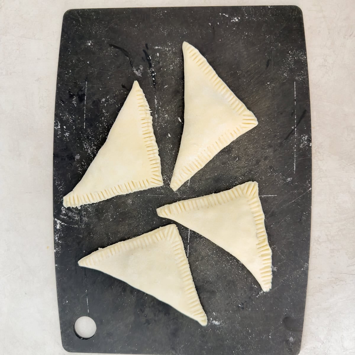 Puff pastry triangles folded around apple filling.