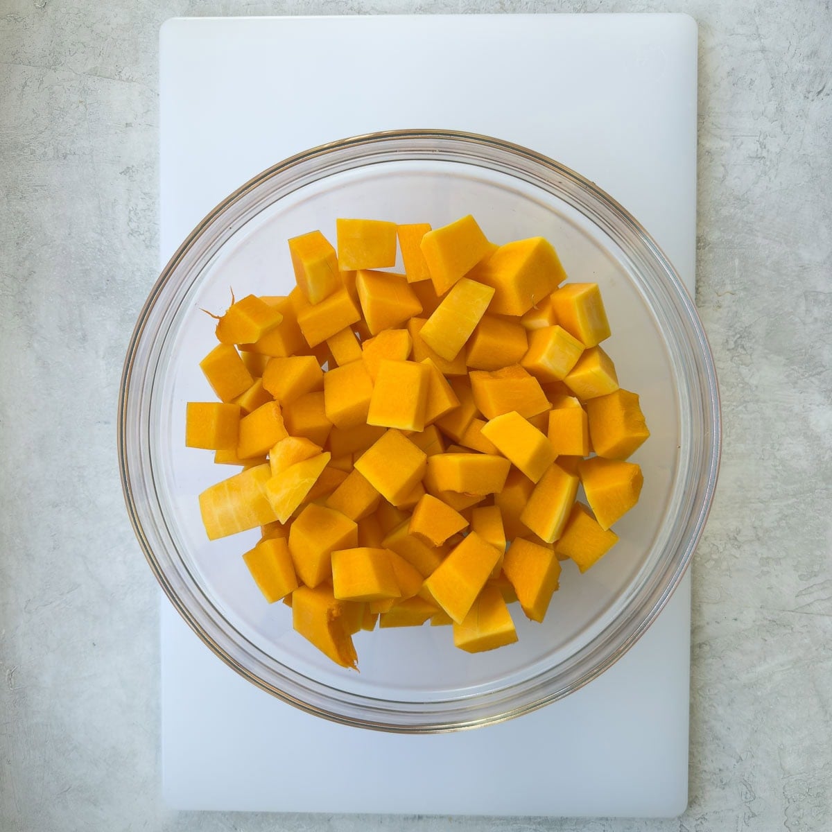 A bowl of bright orange cubed butternut squash.