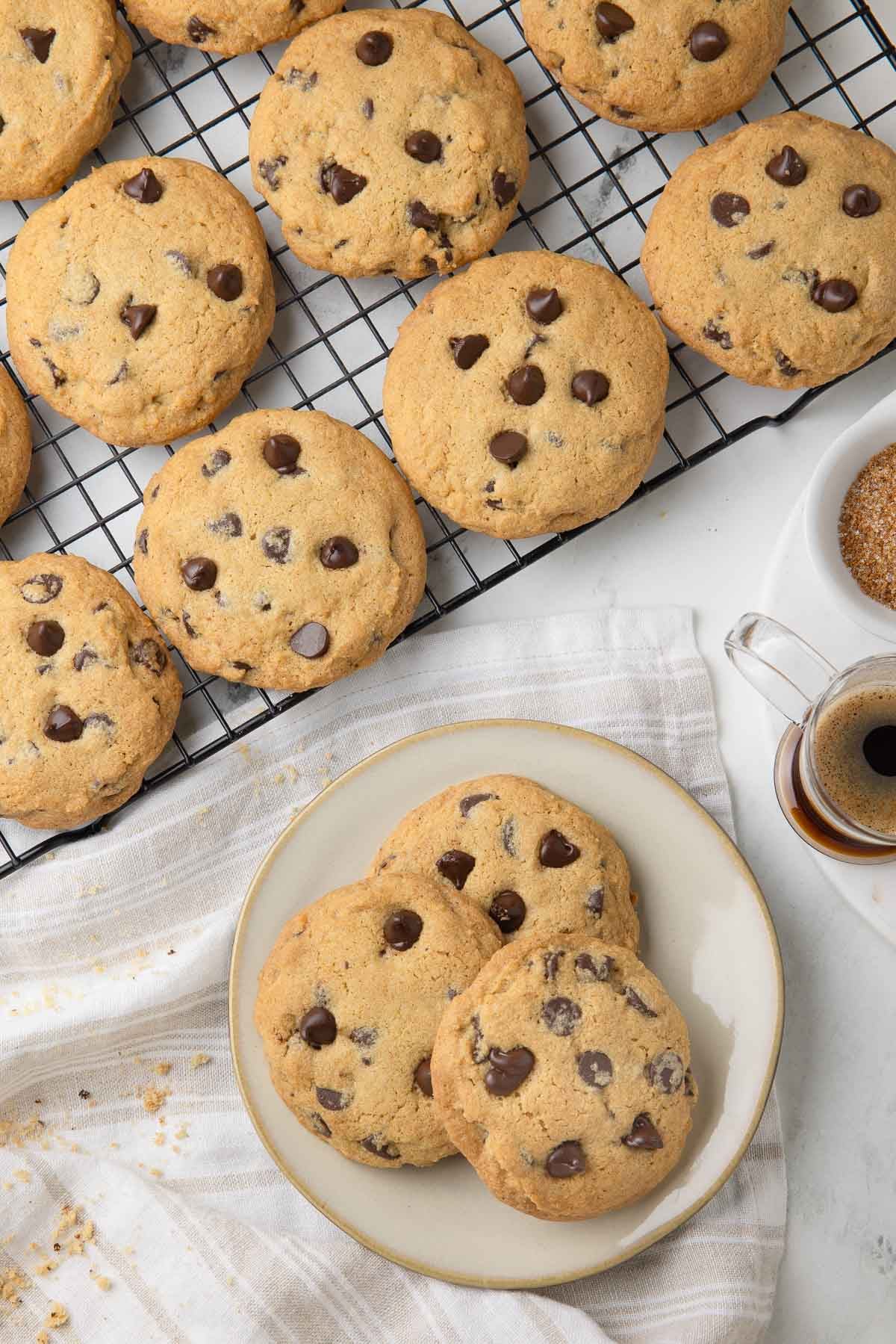 Golden chocolate chip cookies on a cooling rack and small plate. 
