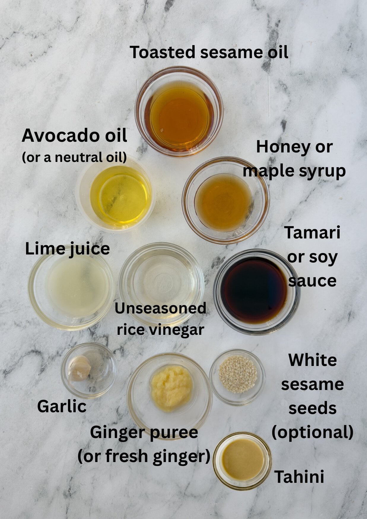 Sesame ginger dressing ingredients in prep bowls on a counter.