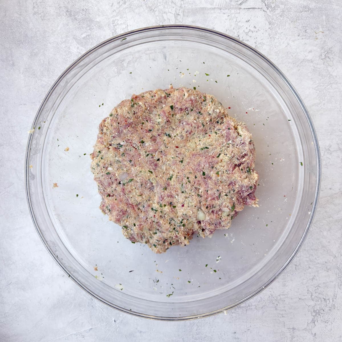 A finished ricotta meatballs mix in a glass bowl ready for rolling.